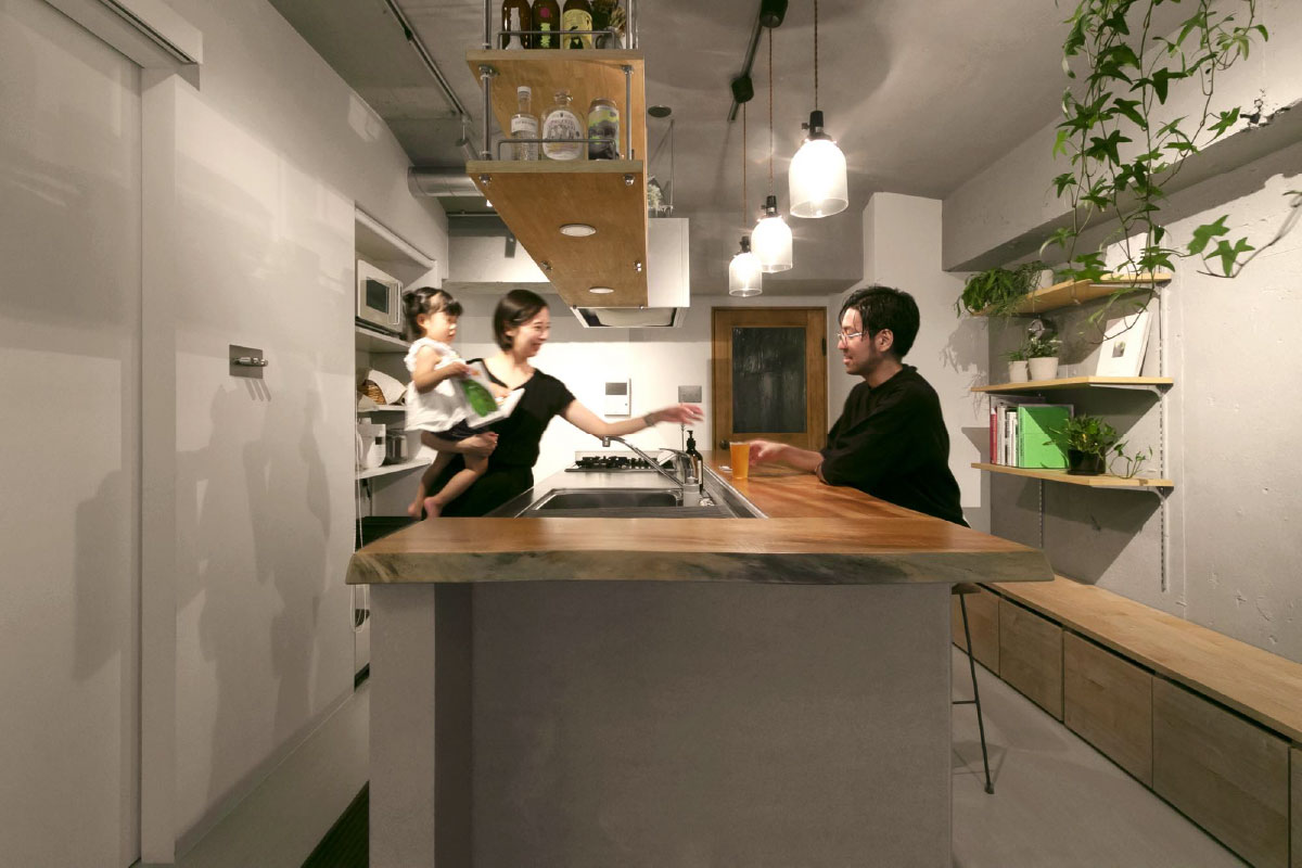 バーカウンターのある家の対面型カウンターキッチンで談笑するご夫婦