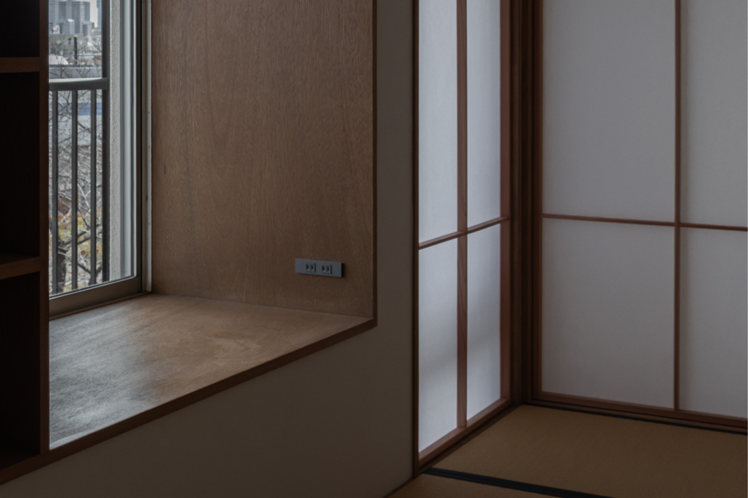 コンセントが目立たないよう、黒いプレートを設置した木張りの窓辺